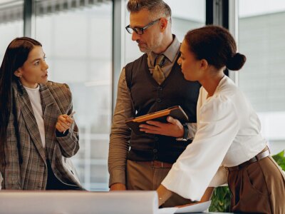 A diverse group of professionals actively participating in discussion and collaboration at a modern workspace.