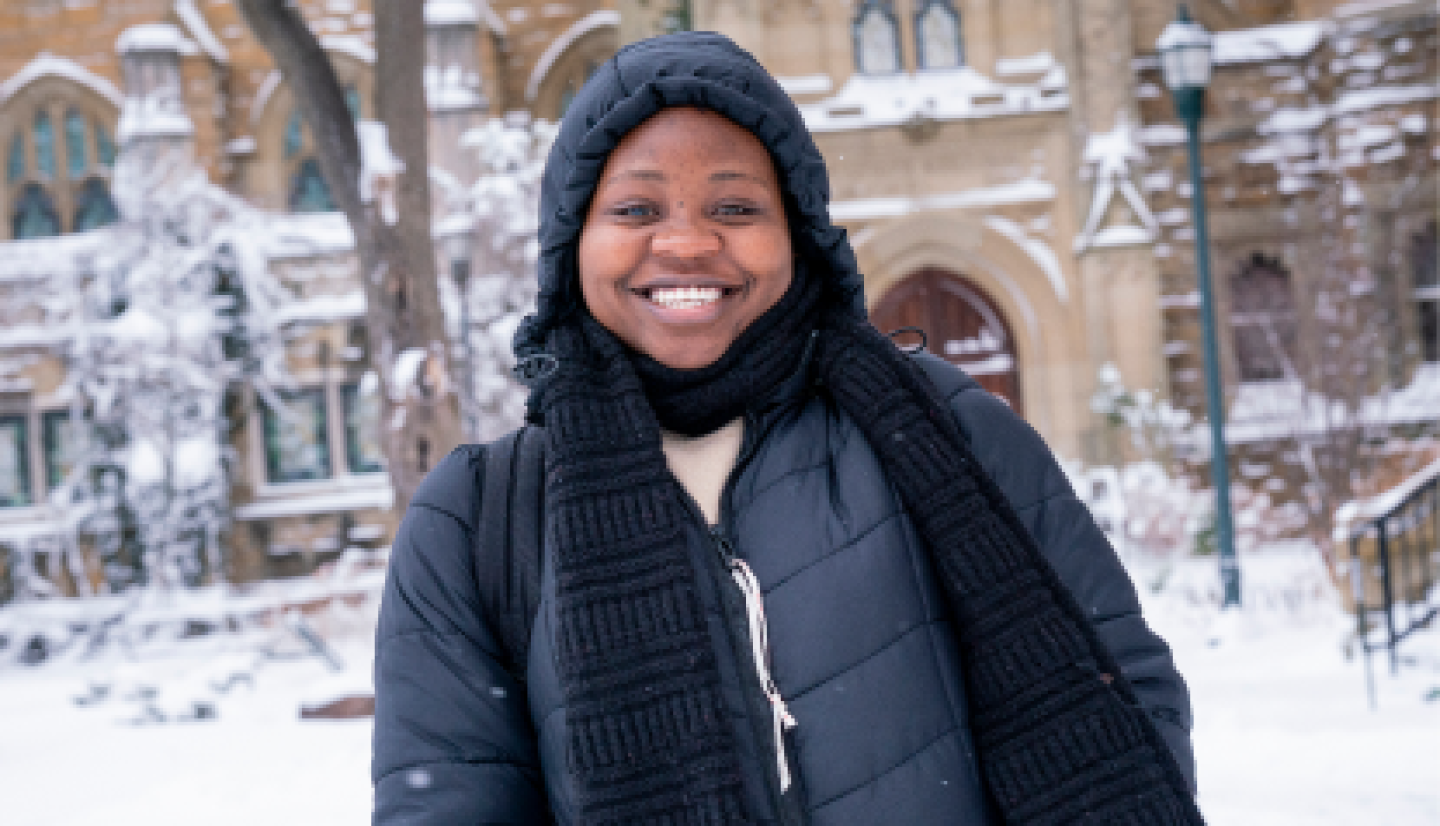 A smiling female CWRU student standing on campus grounds during winter.