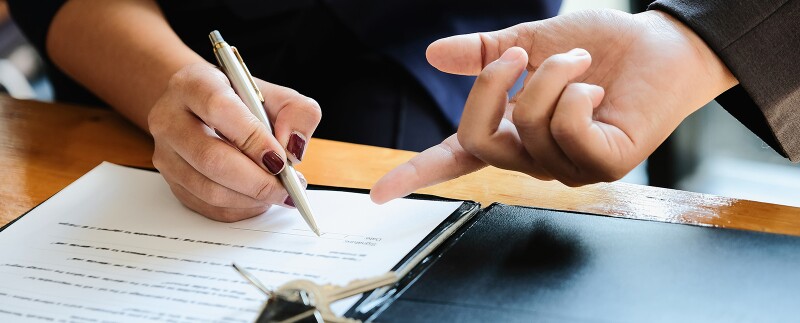 Real estate agent and customer signing a contract