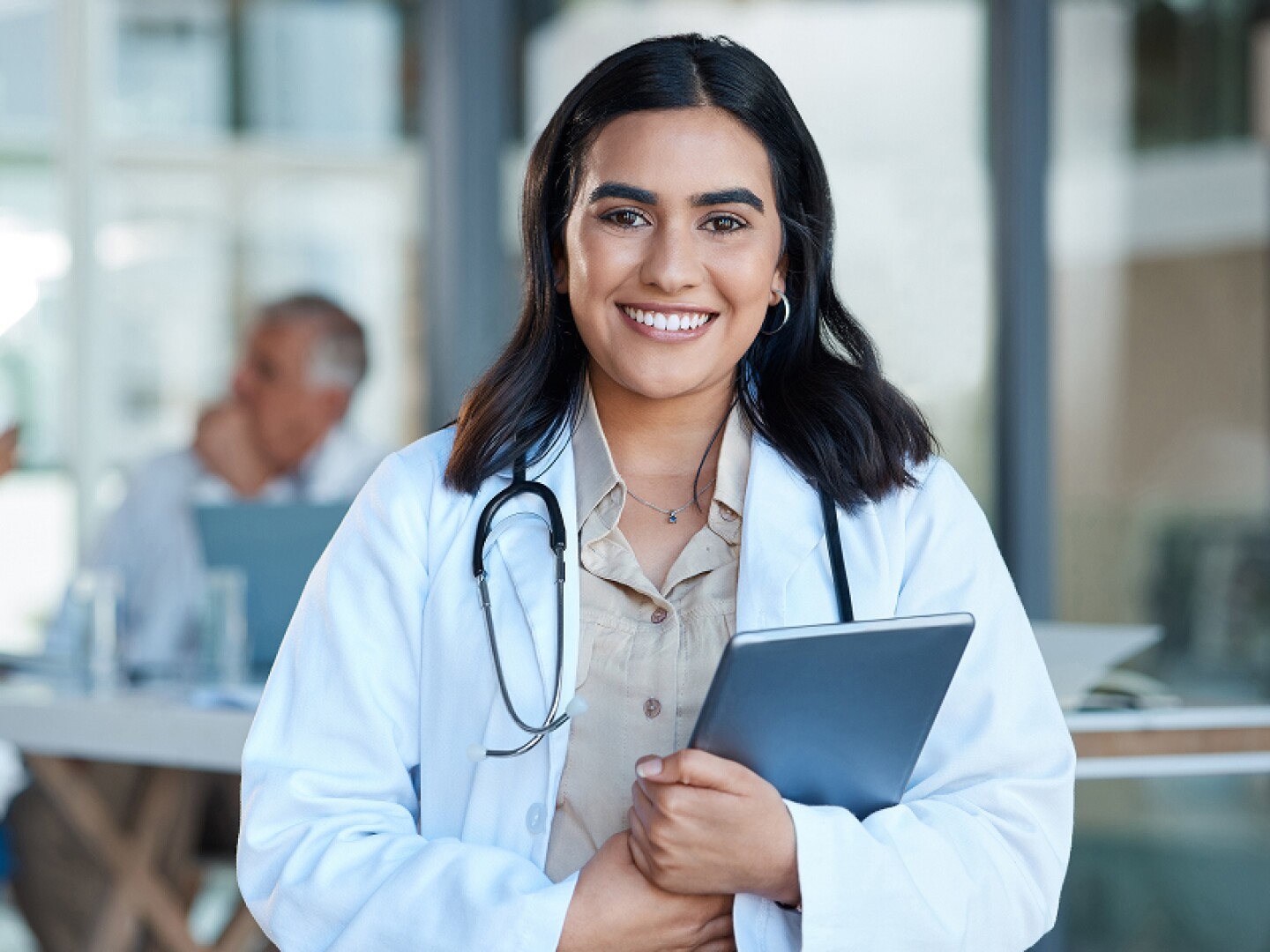 Smiling female physician holding a tablet