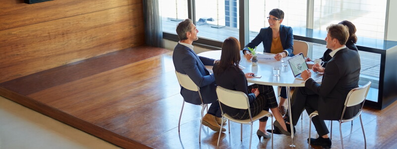 A female finance expert leads a collaborative meeting of colleagues