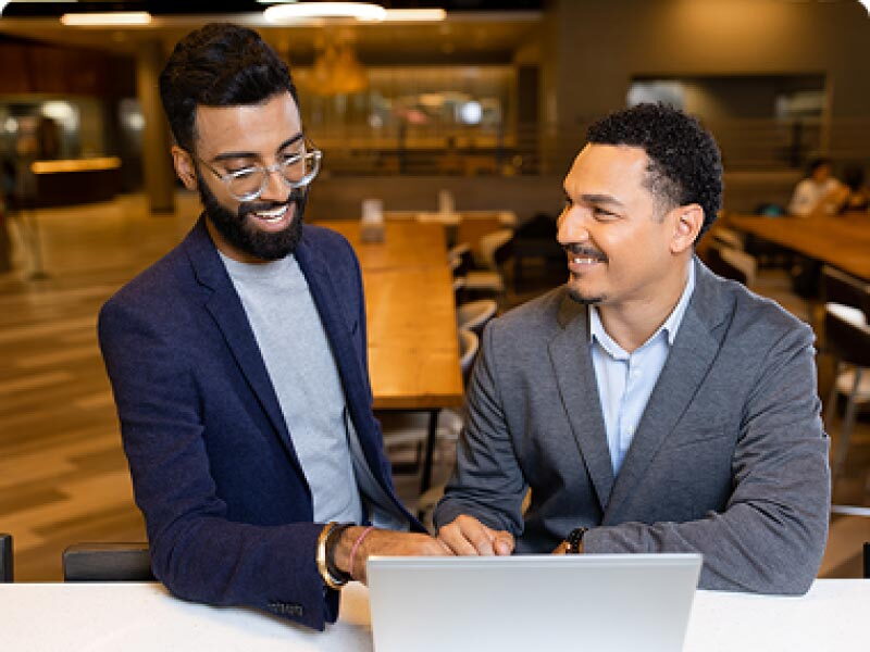 Two SCU students at a laptop having a discussion