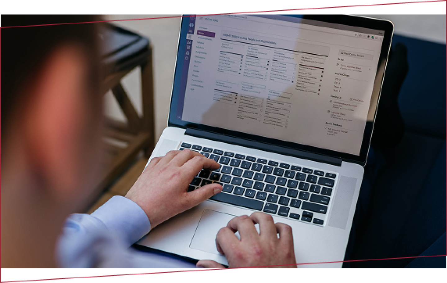 over the shoulder view of a person working on a laptop entering data