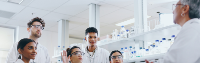 A diverse group of clinical researchers in lab listening during a discussion