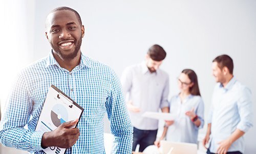 male student holding a clipboard showing pie chart