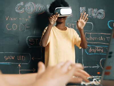 Boy wearing virtual reality glasses in an innovative class.