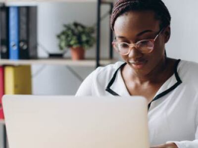 focused woman sitting at desk using laptop