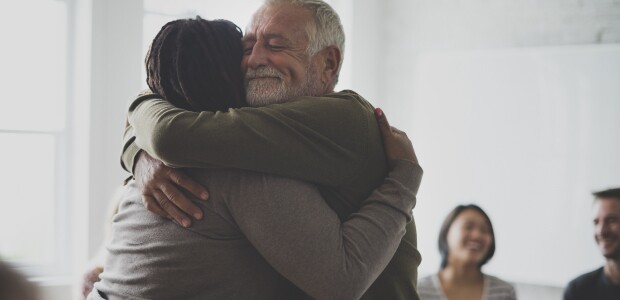 counselor and patient hugging in group therapy