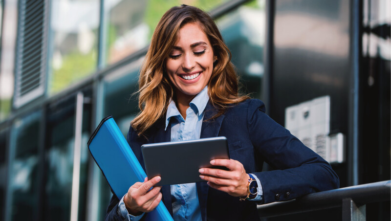 woman smiling looking down at her tablet