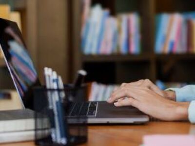 person sitting and typing on a laptop