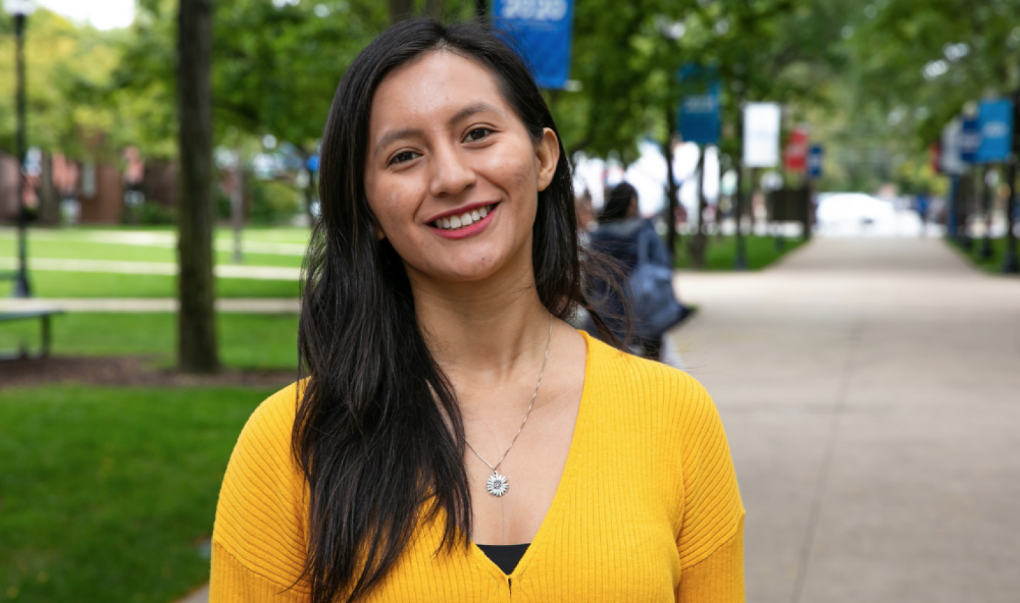 Woman in yellow top smiling on DePaul campus