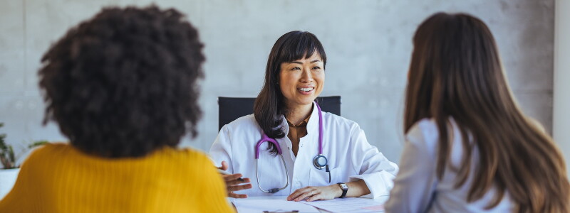 A physician discusses a clinical trial with two possible participants