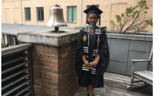 african american female student in college graduation gown