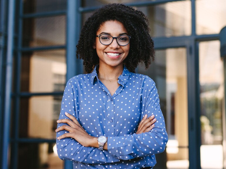 lady in blue top with crossed arms smiling