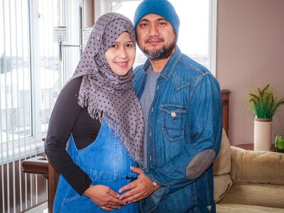 Immigrant husband with his pregnant wife inside their home.