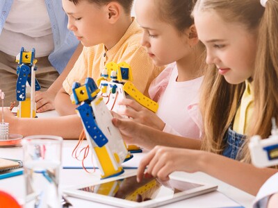 Young students build robots with an adult helping.jpg