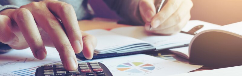 Close up hand man doing finance and calculate on desk about cost at home office.