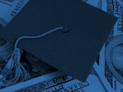 Graduation cap on top of dollar bills