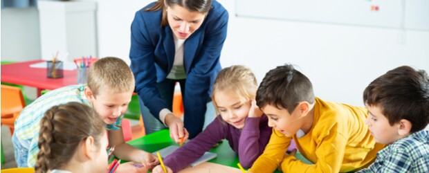 A teacher working with a group of young students to create a growth mindset classroom atmosphere.