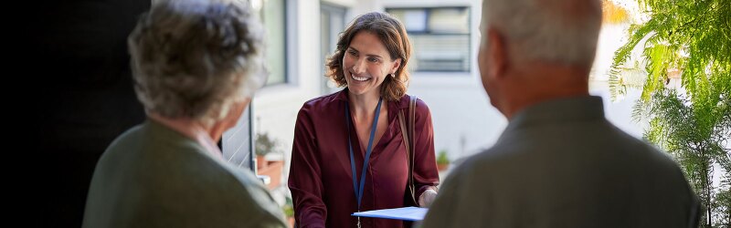 smiling social worker in working session with elderly couple