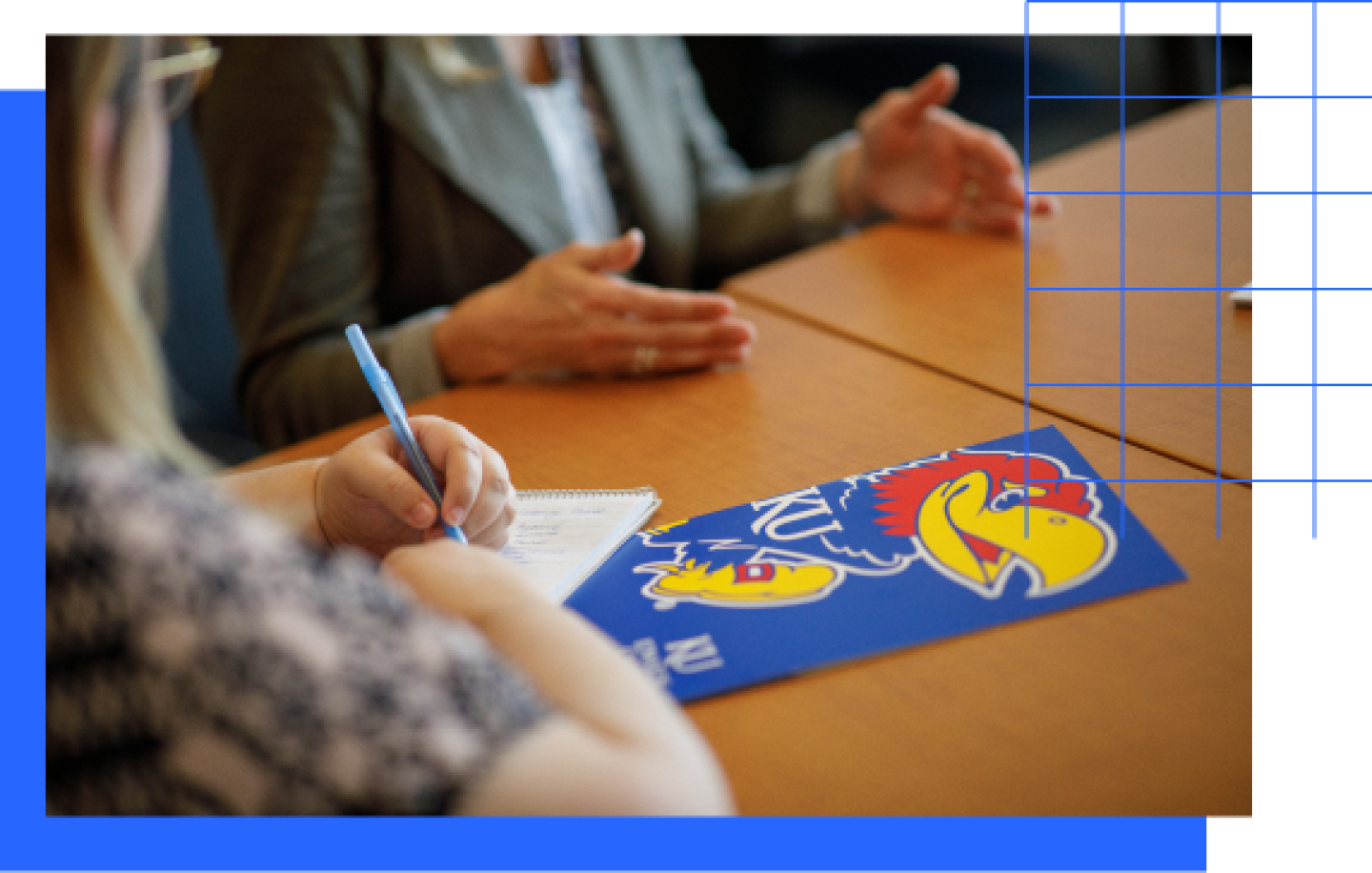 A KU Student Success Coordinator review enrollment with prospect student, with KU brochure on table.