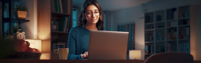Young woman working with her laptop at night