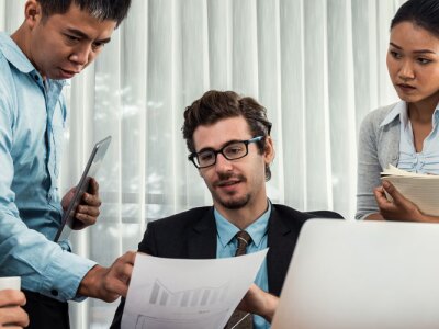 Diverse group of business analyst team analyzing financial data report paper on office table.