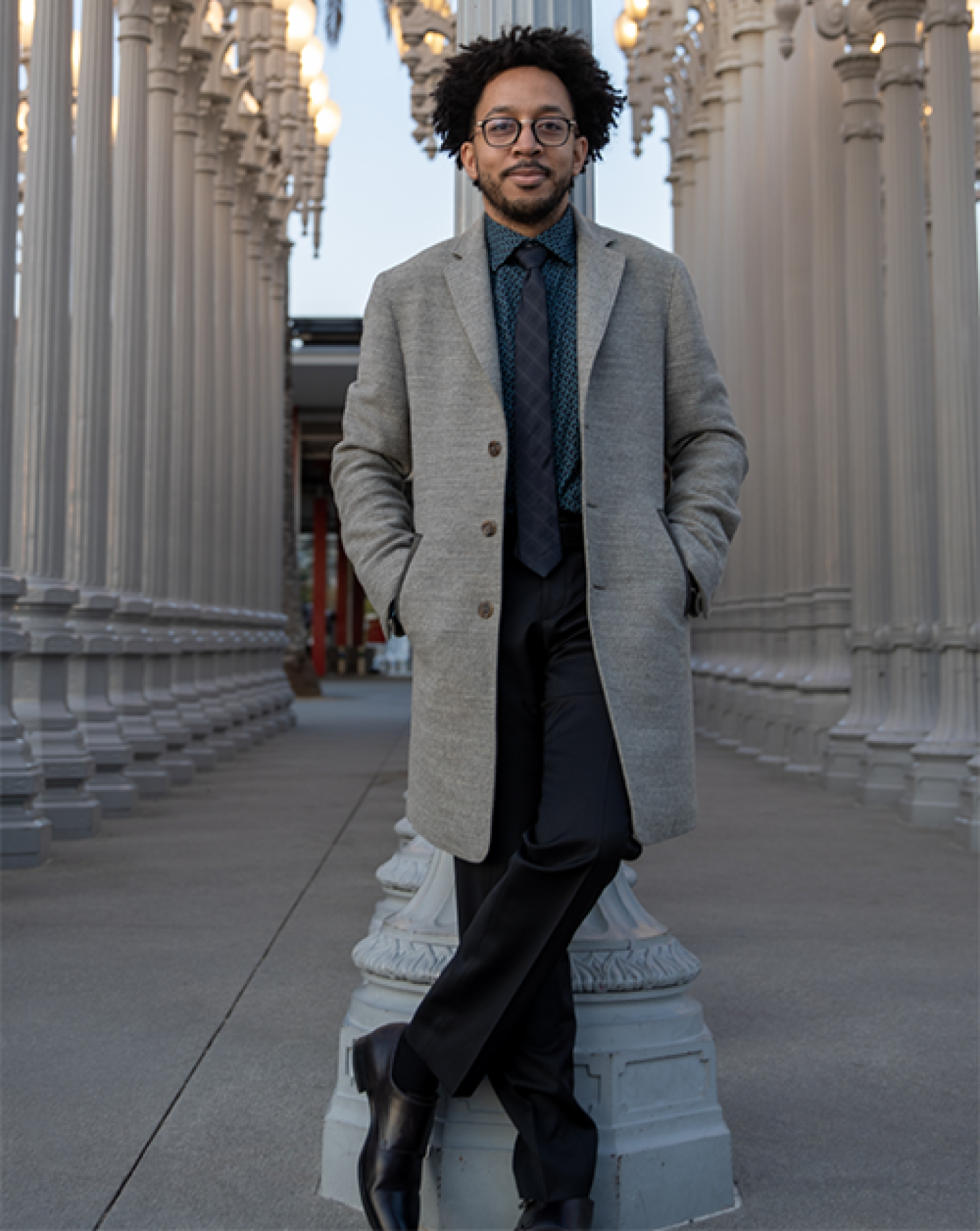 Seattle Albers MBA student in coat and tie standing among rows of columns