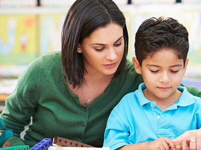 Teacher and Student Working Together With Math Counting Cubes