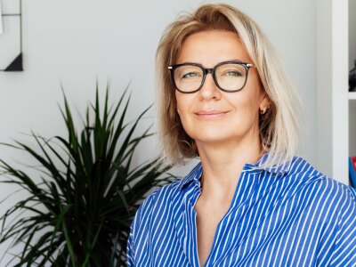 Successful female Civil Rights Advocate Smiling To Camera Sitting On armchair In Office.