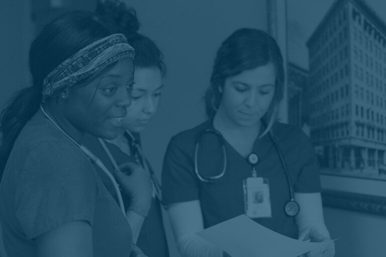 Three nurses looking at a document