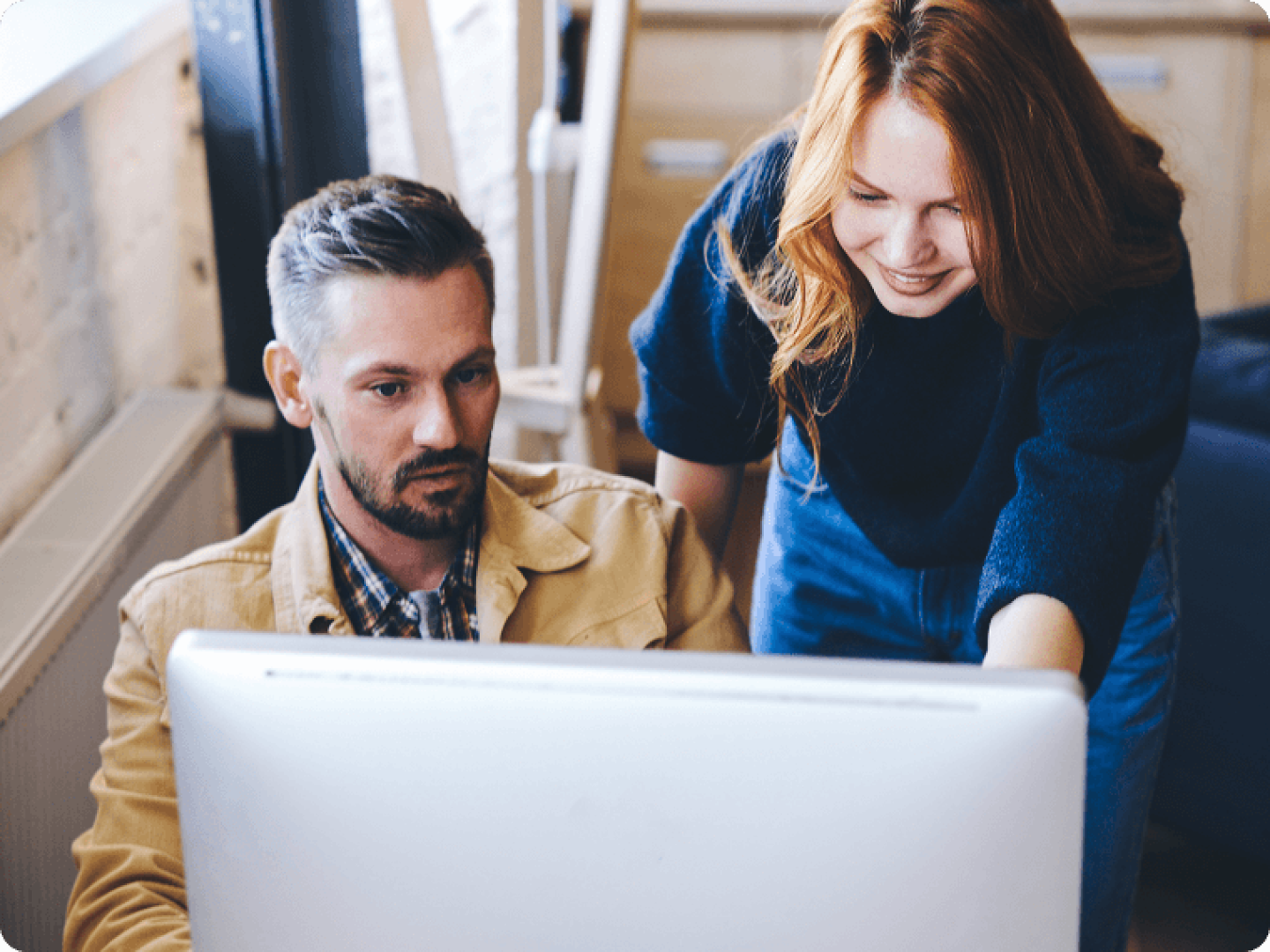 Man and woman looking at desktop screen together
