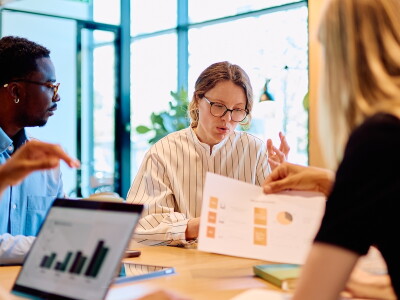 Researchers discussing statistical charts during a collaborative meeting.
