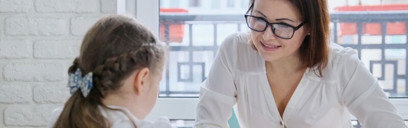 A young girl speaking with a school counselor.