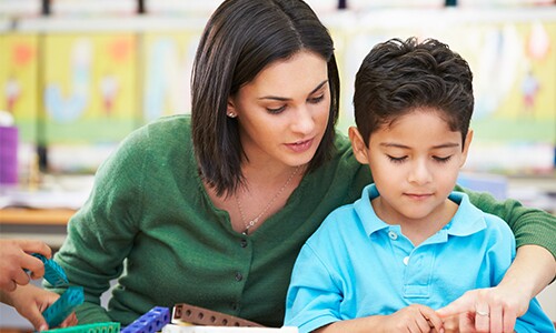 Teacher and Student Working Together With Math Counting Cubes