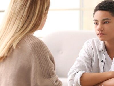 Young female counselor working with teenage boy in office.