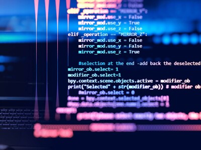 Programmer in front of desktop computer writing code