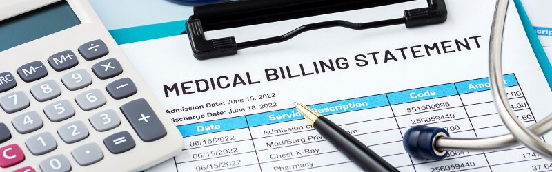 A medical billing statement, pen, and calculator