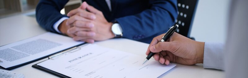 Finance manager reviews a risk assessment report with a colleague during an office meeting.
