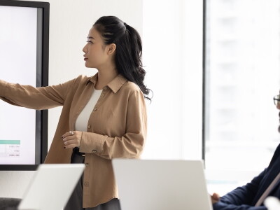 Business analyst presents data visualizations to colleagues during a meeting.