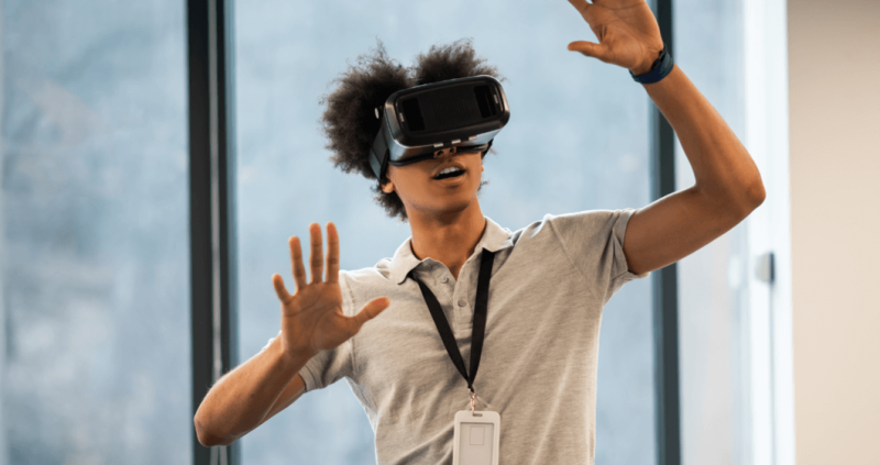 Man raising arms while wearing virtual reality googles