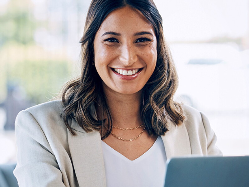 Smiling woman at a desk on a laptop