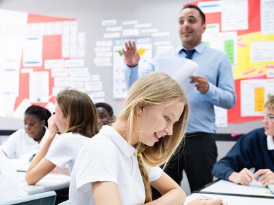 A teacher in a classroom full of students.