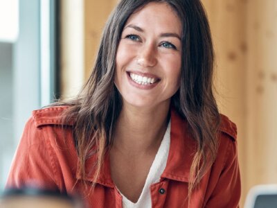 Smiling young business woman listening her partner on coworking space.