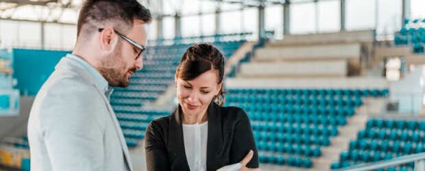 Professionals look over paperwork in sports complex