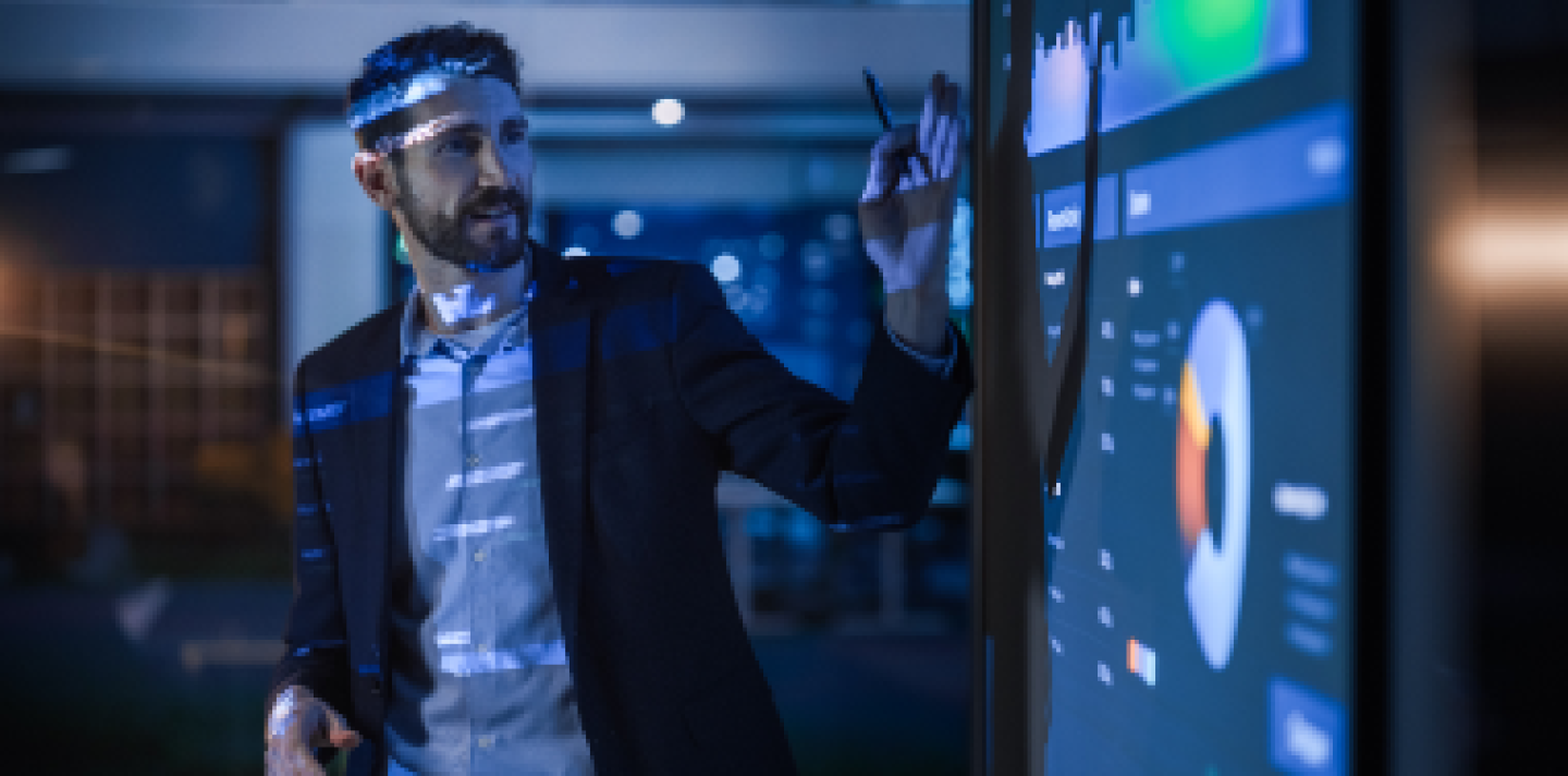man pointing at a screen with a PowerPoint