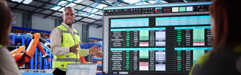 Training A Diverse Group Of Warehouse Workers On Supply Chain. Presenting A Dashboard To Them