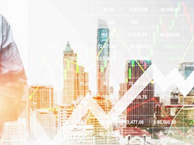 Businessman standing with tablet real estate investing graphic