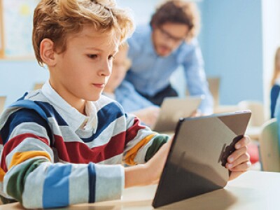 Boy working on tablet in classroom