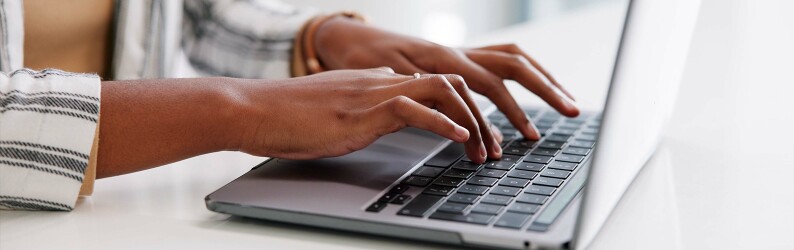 person in striped jacket creating a personal statement on laptop